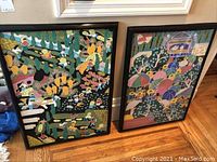 Both framed prints leaning against a wall showing overall size and condition