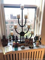 Overall lot on window ledge with multiple decorative and functional items displayed in natural daylight