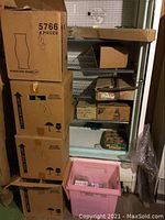 Boxes stacked containing glass hurricane shades and other glass candle accessories.