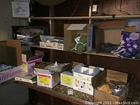 Shelves with boxes containing floral supplies such as bouquet holders, floral ties, floral clay, and floral boxes.