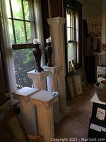 Five plastic columns in front of windows with two candle holders on two of the columns, showing height variety and placement.