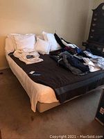 Assembled adjustable bed with mattress, sheet set and pillows; clothing on top not included