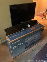 TV on stand next to original Samsung box