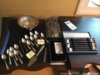 Overall view of lot: tray, spoons, server, stirrers in box and caddy with glass inserts