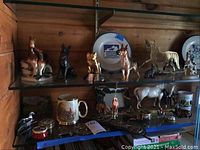 Shelves with assorted equestrian-themed figurines, enamel boxes, Avondale China items