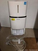 Front wide view of the white Honeywell dehumidifier showing power cord and water collection tray at the base.