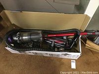 Cardboard box containing Dyson V11 Outsize vacuum and accessories from above