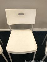 Front view of white IKEA Herman chair showing seat and backrest, with some dirt marks visible.