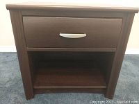 Front view of solid wood dark brown end table with a drawer and open shelf below. Nickel style handle on drawer.