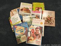 Photo showing 12 cookbooks including You Gotta Eat Here 1 & 2, Quinoa Revolution, The Whole Foods Diet, Healing Foods, The Chatelaine Cookbook, Kitchen Cures, and more.