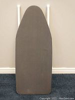 Front view of the ironing board showing its gray fabric-covered surface with minor signs of use.