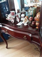 Photo showing entire collection on wooden table including painted eggs and ceramic drinkware.