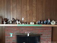 Wide view of various animal figurines on mantel showing layout and number of pieces.