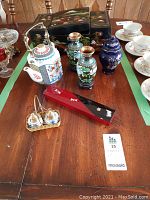 Wide view of the Asian lot showing the lacquered jewelry box, teapot, cloisonné vases, blue ginger jar, salt and pepper shakers, and red lacquered box.