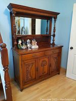 Full view of the antique wood buffet showing the mirror, ornate carved panels, drawers, and doors.