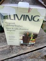 Box of For Living Fitzgerald tabletop fireplace showing front with logo, product name, image, and 10,000 BTUs feature.