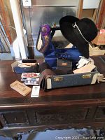 Photo showing full lot on wooden table including gloves, hat, makeup case, shoe cleaning kit, other assorted items.
