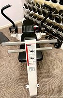 Front view of white steel frame bench with chrome foot bars and black padded seat