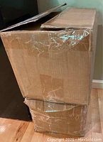 Two large taped cardboard boxes containing books, closed in one photo.