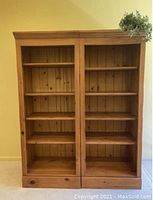 Front view of one knotty pine bookcase showing four shelves and bottom drawer with knob.