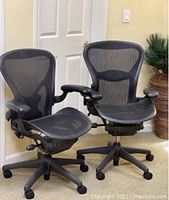 Front view of two black mesh ergonomic chairs side by side
