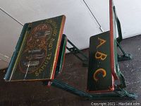 Front-angle view of full desk with attached bench, showing painted green and red frame and bench seat lettering ‘ABC’.