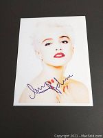 Front of signed Madonna photograph on black surface, showing signature and portrait.