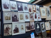 Overview of 24 antique children cabinet cards arranged on a surface showing various solo and group portraits in vintage style and wear.