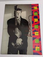 Front cover of tour book showing black-and-white portrait of Paul McCartney with bass and full autograph
