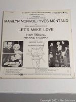Back cover of Columbia Records LP "Let's Make Love" showing cast images and track listing with handwritten signature.