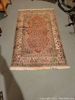 Full view of rectangular silk rug showing overall design, color and fringe