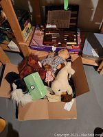 Box with assorted plush toys and jewelry box visible