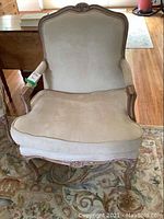 Full frontal view of the Berger style occasional chair showing overall shape and design with beige upholstery.