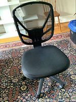 Front view of black mesh back office chair showing mesh backrest, padded seat, and part of wheeled base