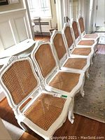 Six chairs in a row, full view of frames and cane seats