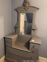 Full front view of the wooden dresser showing 6 drawers and a tall attached mirror with carved details.