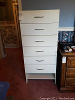 Front view of one white drawer unit with six drawers and bottom open shelf space, silver handles