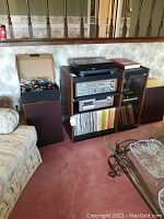Full view of stereo components on wood shelf with Sony turntable on top, Technics receiver, Pioneer tape deck below, and speakers on either side