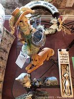 Image showing a collection of animal figurines including dog, pig, and a large cat on a circular wreath with painted phrase