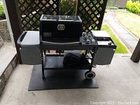 Full view of grill showing overall condition, side tables, under-shelf and wheels