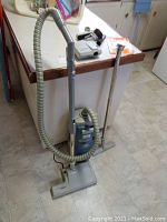 Full view of Electrolux Regency Series 2000 vacuum standing upright with hose, wand and attachments.