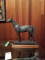 Full side profile view showing entire sculpture and wood base