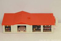 Top-down angled view of the Hot Wheels Supercharger playset showing the red roof and beige structure with racing-themed illustrations on the sides.