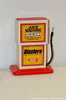 Front view of the Juice Machine showing the Sizzlers and Juice Machine decals, with red base and connected black cable.