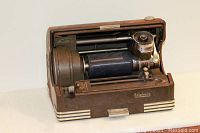 View of interior mechanism showing recording cylinder, playback arm, and brand logo.