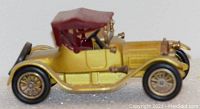 Side view of 1913 Cadillac diecast model showing yellow body and maroon convertible roof.