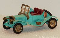 Side view of the light blue 1911 Renault die-cast model car showing maroon interior, brass detailing on radiator and headlights, and brass spoke wheels.