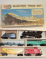 Top-down photo of the Lionel train engine, tender, and four train cars arranged in the original packaging tray.