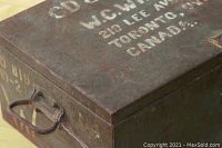 Top and side view showing metal box with stenciled text indicating name and address in Toronto, Canada along with other markings.