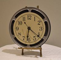 Front angle view of the clock showing the movie reel frame and clock face.